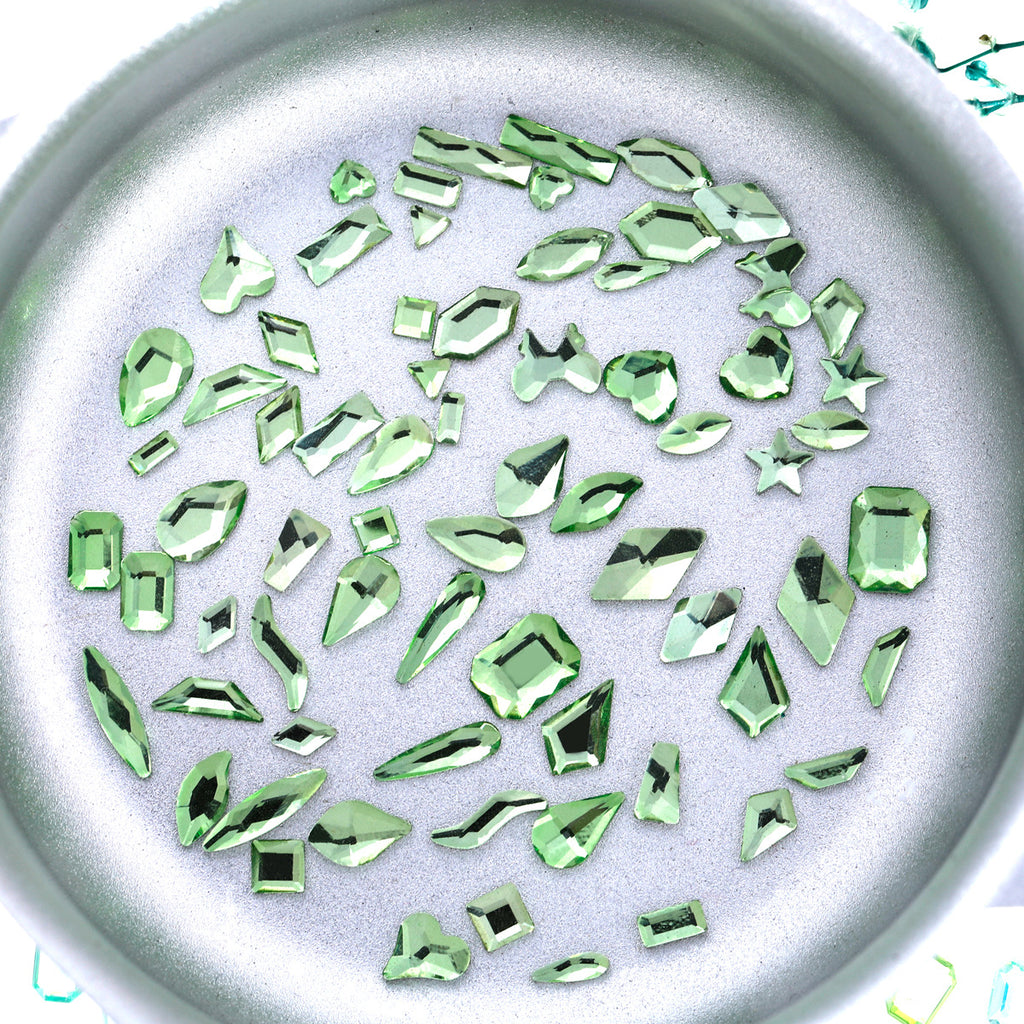 Nail art featuring a mix of unique shapes, flat-bottomed glass rhinestones, ultra-sparkling light green gel nail art, trendy and Instagram-worthy.