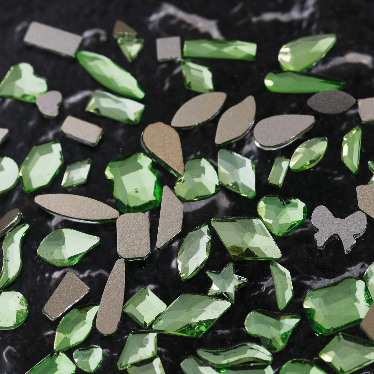 Nail art featuring a mix of unique shapes, flat-bottomed glass rhinestones, ultra-sparkling light green gel nail art, trendy and Instagram-worthy.